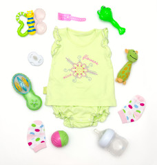 top view of baby girl green clothes and toy stuff
