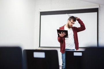 Young teacher thinking in empty classroom
