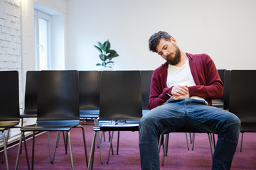 Young man falling asleep at conference room