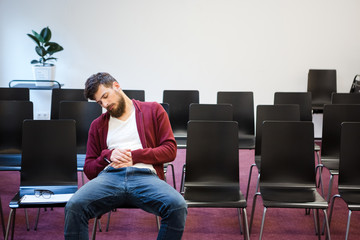 Bearded guy sitting and sleeping in conference room