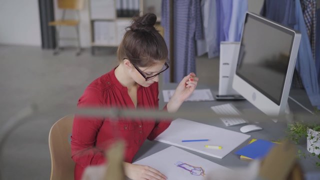 modedesignerin zeichnet einen entwurf von hand