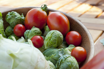 cherry tomatoes, brussels sprouts with broccoli on a wooden tabl
