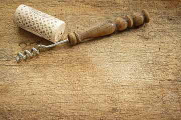 Wine cork and corkscrew on wooden table