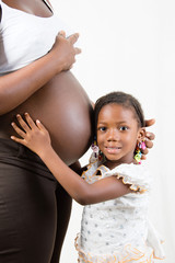 fillette heureuse d'écouter bébé dans le ventre de maman.