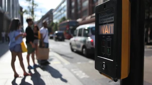  People wait at pedestrain crossing in London