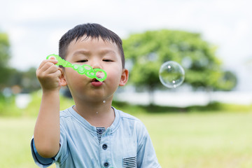 Cute boy blowing a soap bubbles