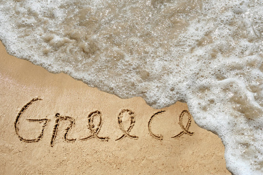 Conceptual Greece text in sand and water