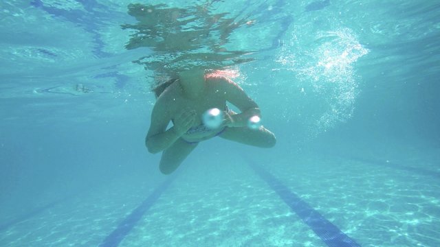 Female model smiling swimming underwater