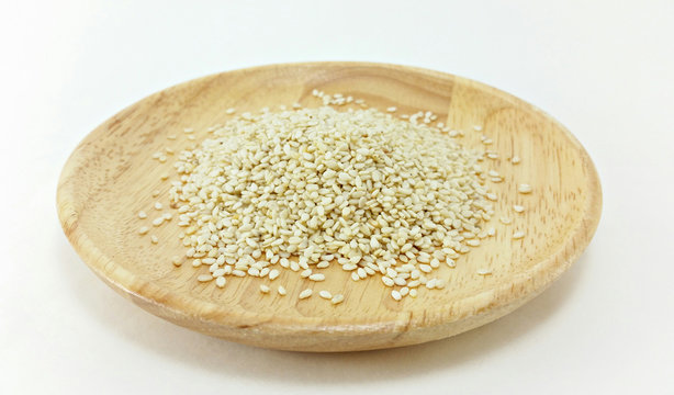 white sesame in wooden plate on white background