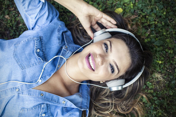 Beautiful girl listening to music in a park