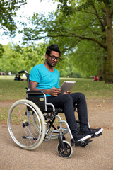 young man in a wheelchair using a tablet computer