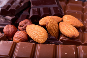 Milk and dark chocolate with whole hazelnuts and almonds closeup