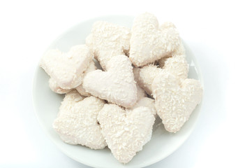 heart shaped cookies with white chocolate with coconut on a plat