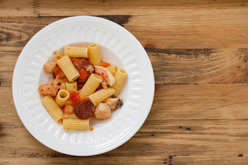 pasta with dry tomato and sausages on plate