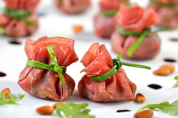 Leckere Schinkensäckchen aus Bresaola, gefüllt mit Rucola, gerösteten Pinienkernen, Parmesan und Crema di Balsamico