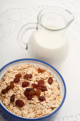 oatmeal with raisins with milk on a white tablecloth
