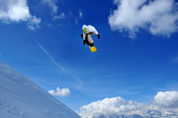 Naklejka na ściany i meble snowboarder in green and white performing a jump