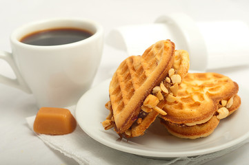 cup of morning coffee and fresh waffles in the shape of heart on