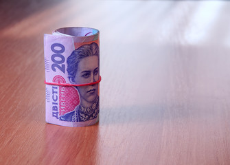 Bank Roll of Ukrainian hryvnia on the table