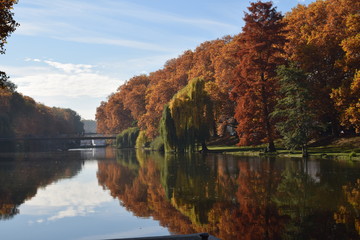 Harmonische Herbststimmung mit Herbsthimmel, Fluss und roten Bäumen  - obrazy, fototapety, plakaty