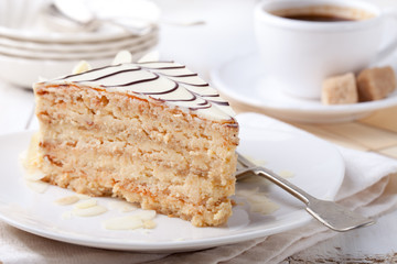 Traditional Hungarian Esterhazy cake with coffee cup and vintage postcards .