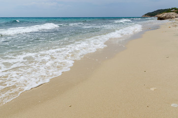 Sea shore view with white waves and sand