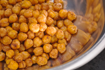 Chickpeas baked with spices in metal bowl closeup