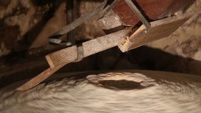 Millstone in a water mill grinds corn 3 of 7