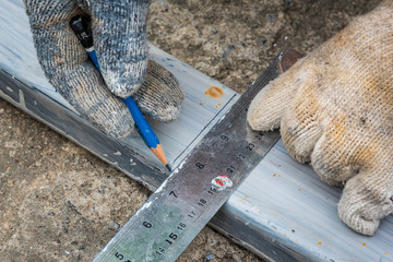 Worker measurement the steel with square triangle scale to preparation for cutting steel