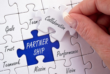 Partnership Business Concept - female hand with puzzle and text