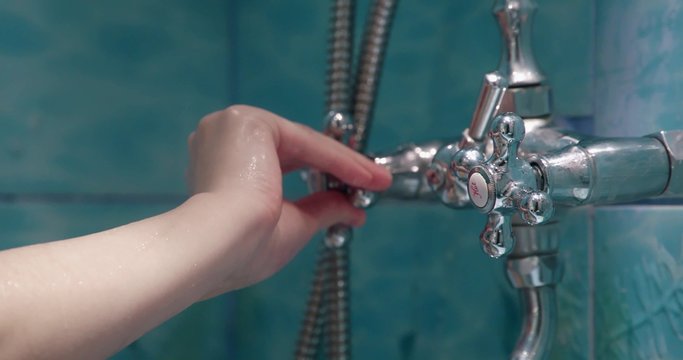 closeup of the faucets of a shower with a shower hand