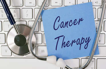 Cancer Therapy - blue note paper on computer keyboard with stethoscope