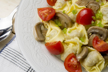 Homemade tortellini stuffed with mushrooms and spring onion and cherry tomatoes