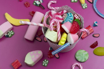 Mixed colorful candy on pink background, kids holidays