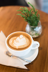 Hot art Latte Coffee in a cup on wooden table