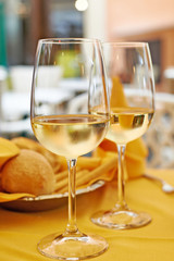 Glasses of white wine and salad on table cafe