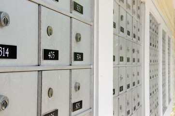 Closeup of rows of locked metal apartment or condominium mailboxes