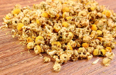 Dried chamomile on wooden table, alternative medicine