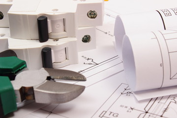 Work tools, electric fuse and rolls of diagrams on construction drawing of house