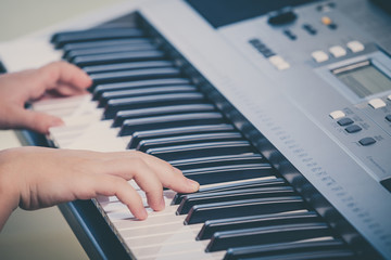 Obraz na płótnie Canvas Little girl playing synthesizer