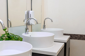 white basins in bathroom interior with granitic tiles