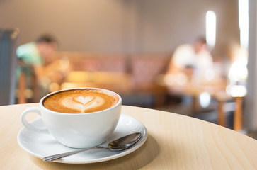 Hot art Latte Coffee in a cup on wooden table and Coffee shop bl