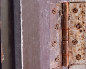 old and rusty door hinge on wooden frame