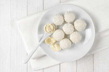 Coconut candies on white wood