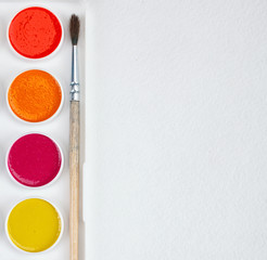 paints for painting and brush on blank white paper sheet