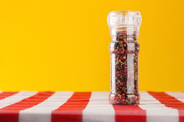 Colored Peppers Mix and pepper mill on tablecloth © Gerisima