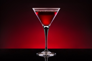 Cherry cocktail in a crystal glass isolated on red black backgro