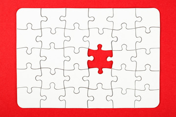 Business conception, puzzle pieces over red background