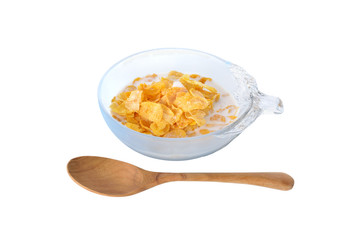 crispy corn flakes with milk in bowl and wooden spoon on white b