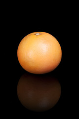 Grapefruit on a black reflective background